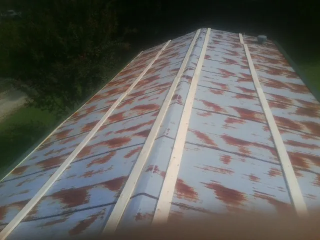Rusted metal roof panels with new wood purlins before replacement — Storm Damage Roof Repair in Splendora by Roofing Brothers