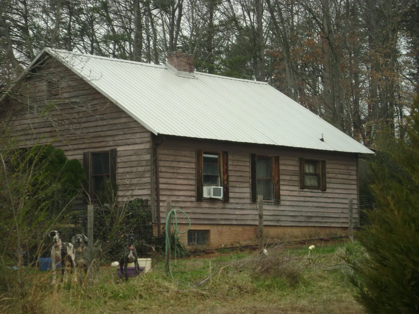White metal roof on an old wood sided farmhouse, from a Metal Roof Installation job in Splendora